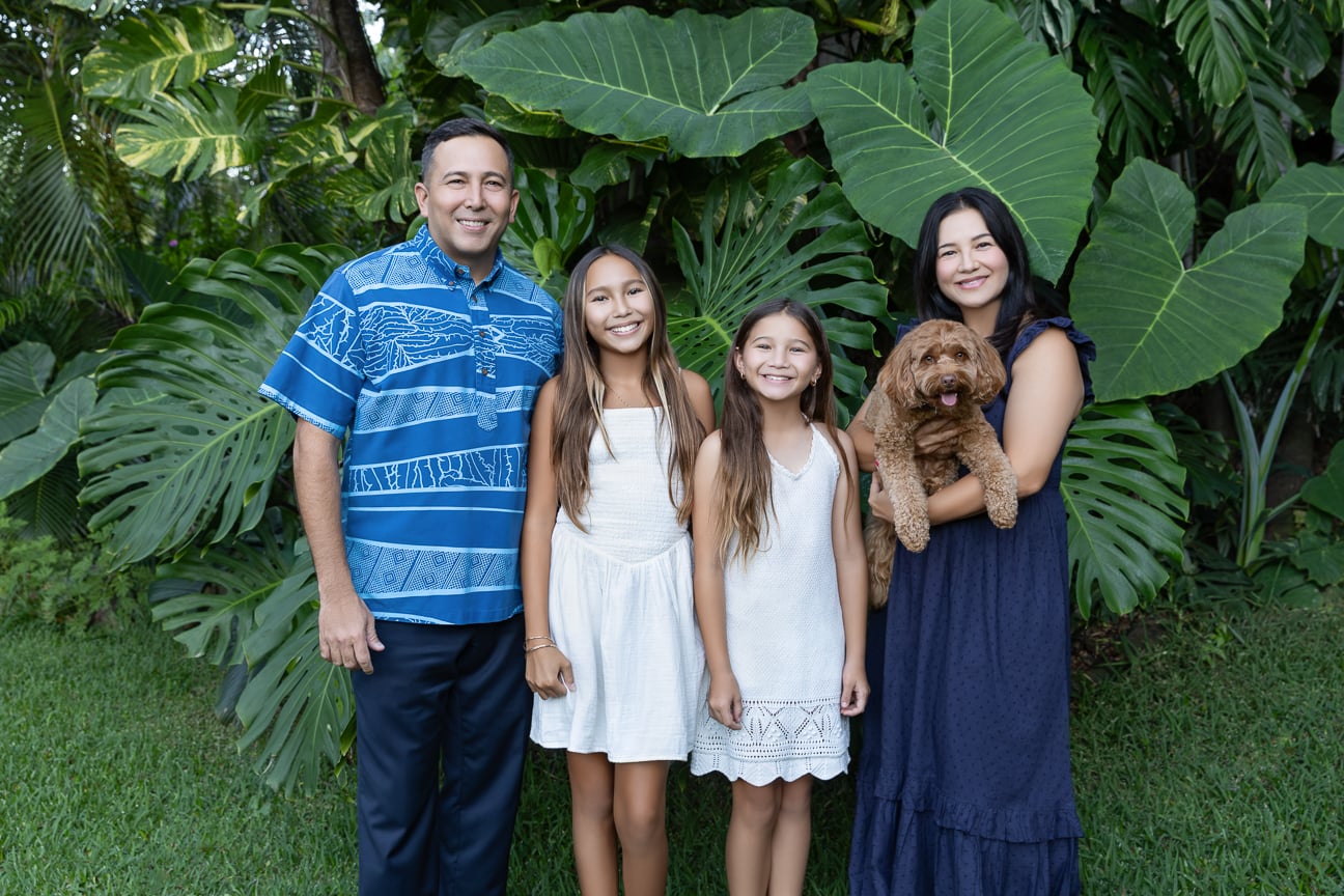 Trevor Ozawa with his family and dog in a tropical garden